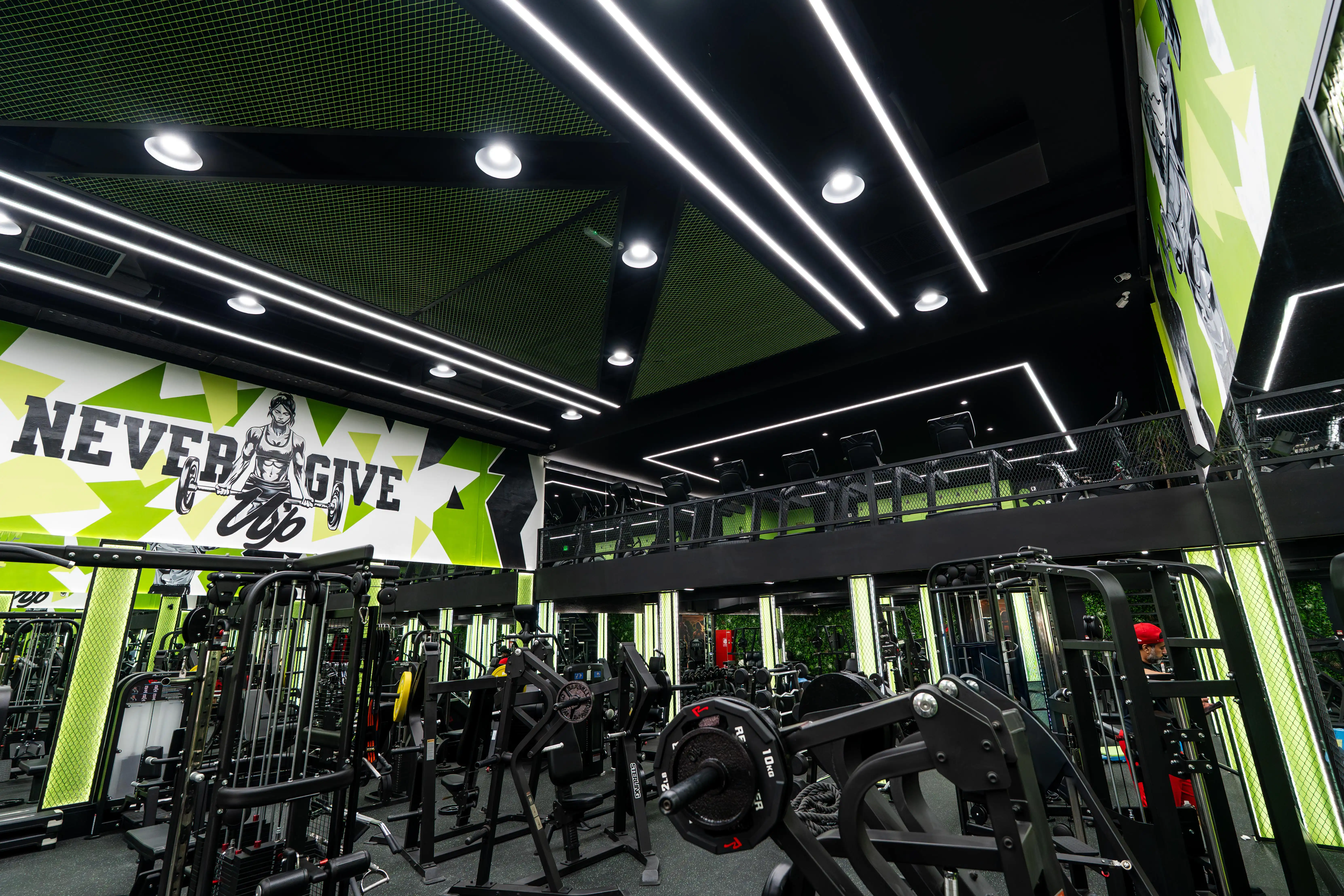 Secret Sport Gym main training floor with NEVER GIVE UP mural and mezzanine level